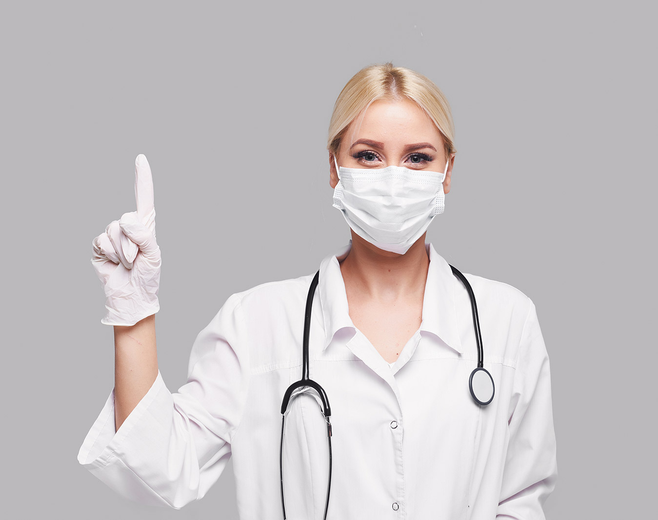Junge Ärztin im Kittel und mit Mundschutz. Thema: Frauenmedizin