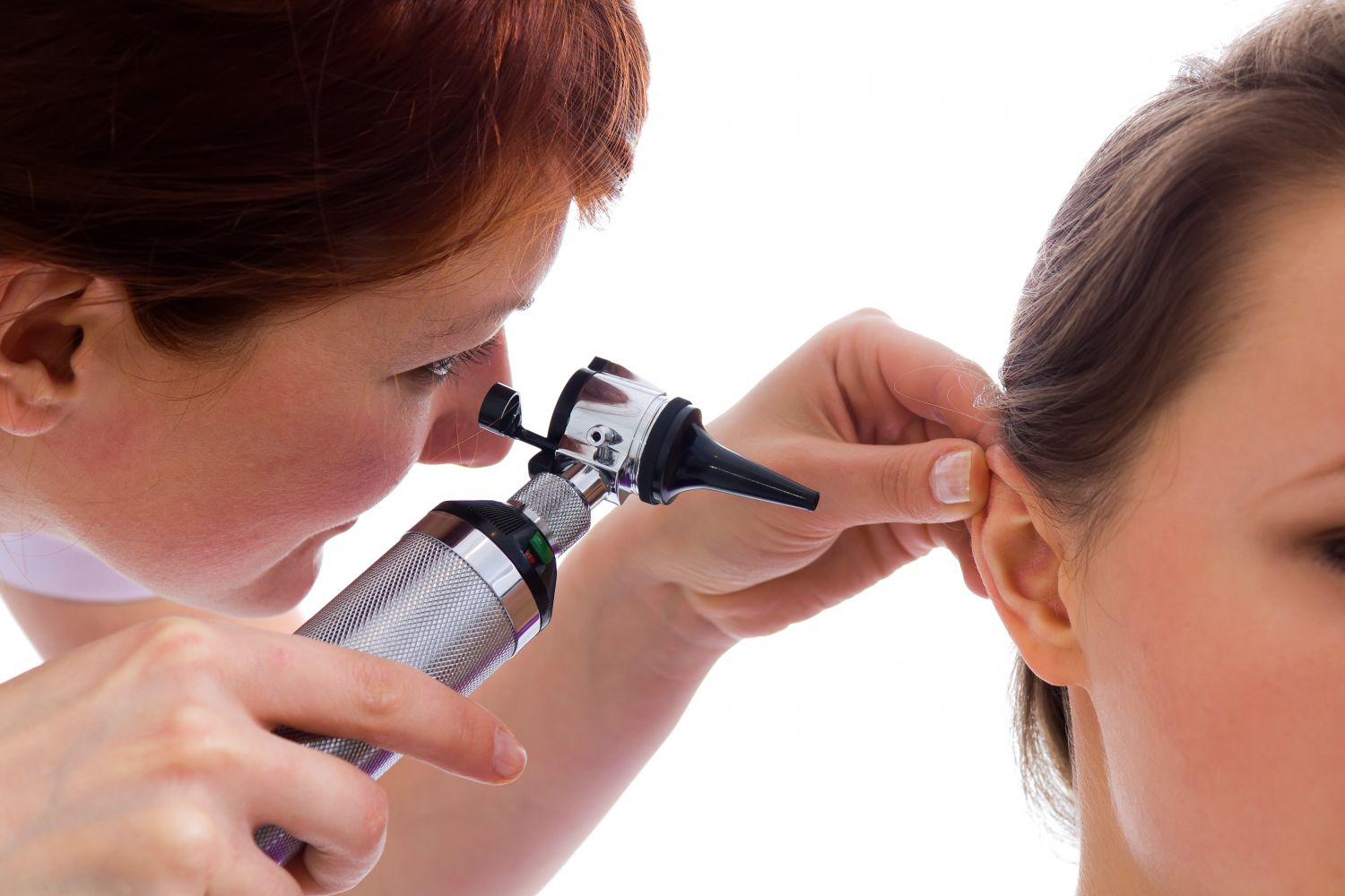  Eine Ärztin untersucht das Ohr einer Patientin. Thema: Ohrenschmalz entfernen